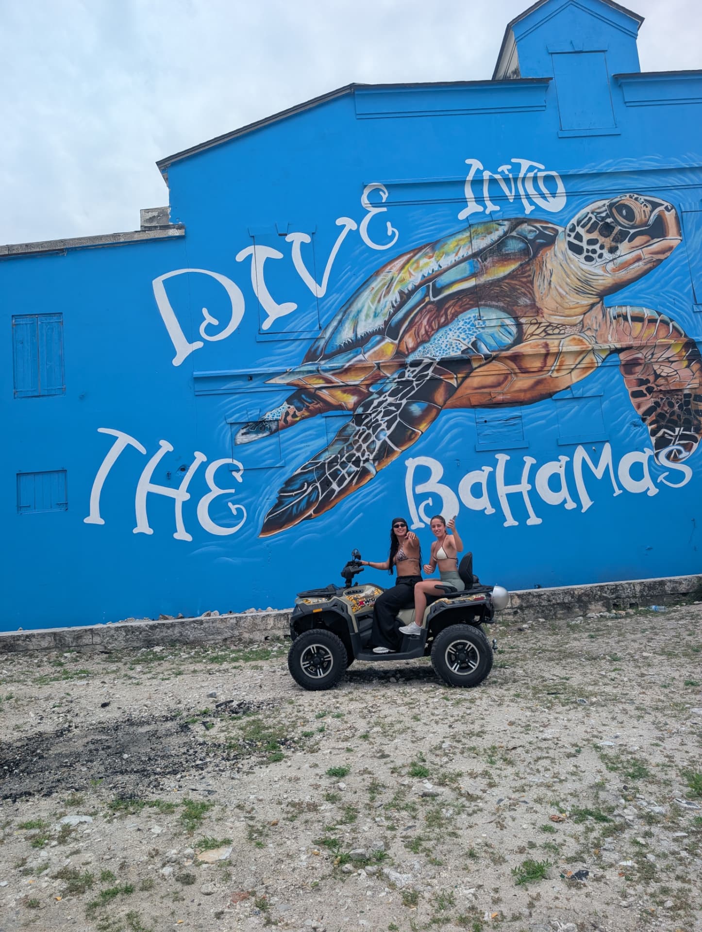 A2B Roadster self-guided ATV in front of The Bahamas mural in Nassau