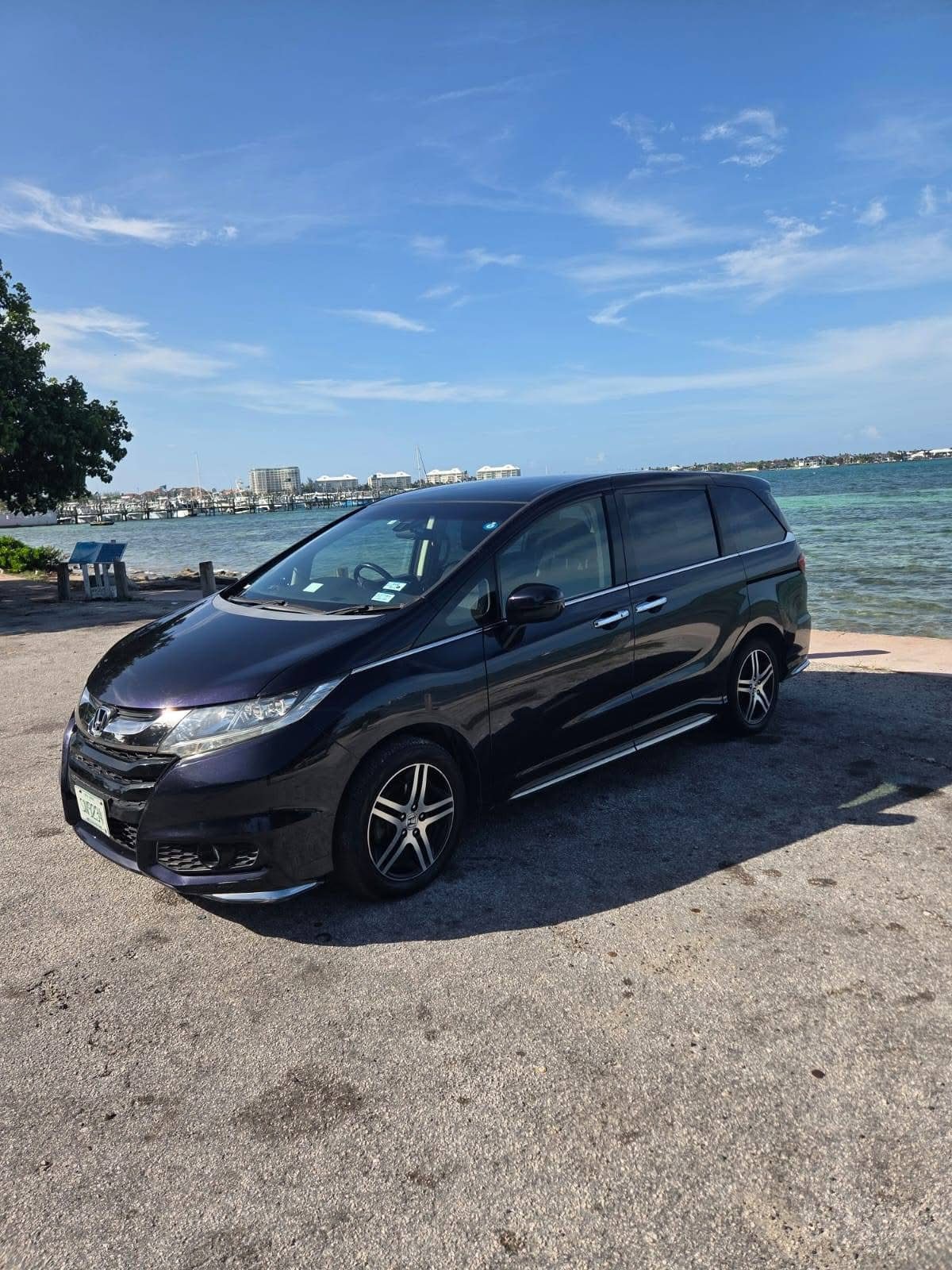 An A2B Honda Odyssey rental parked by the water in Nassau